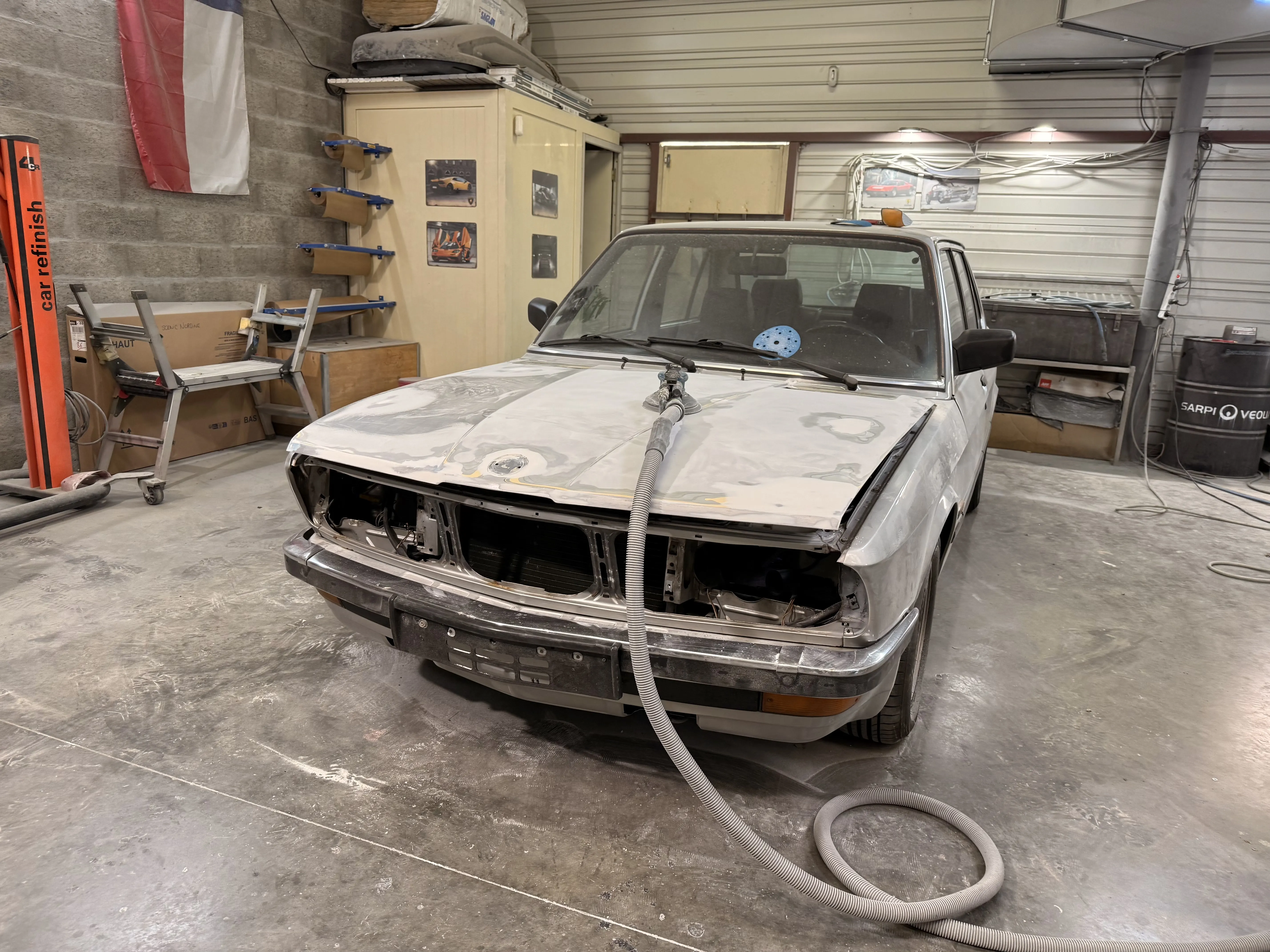 BMW E28 en cours de rénovation de capot dans l’atelier carrosserie AutoMania Atelier à Eysines, près de Bordeaux en Gironde.